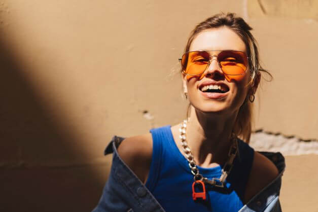 Woman wearing different colours of clothes and sunglasses