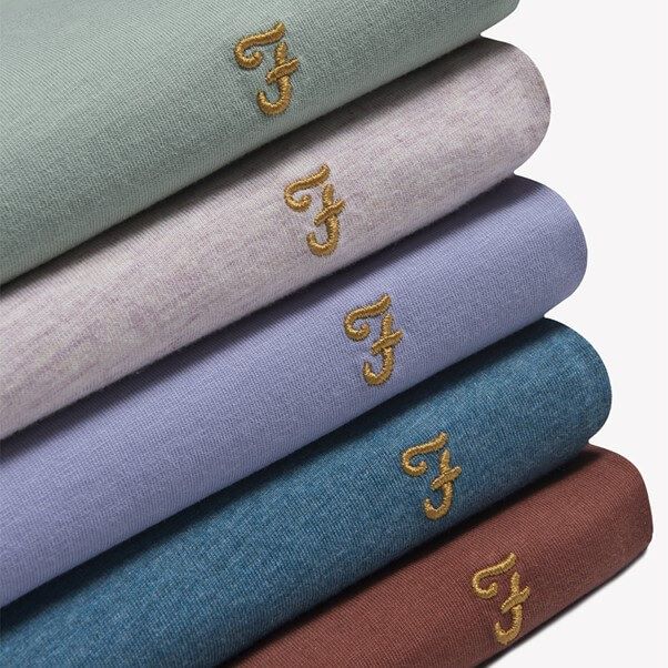 A pile of Farah shirts neatly stacked showing the famous logo