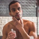 man applies aftershave