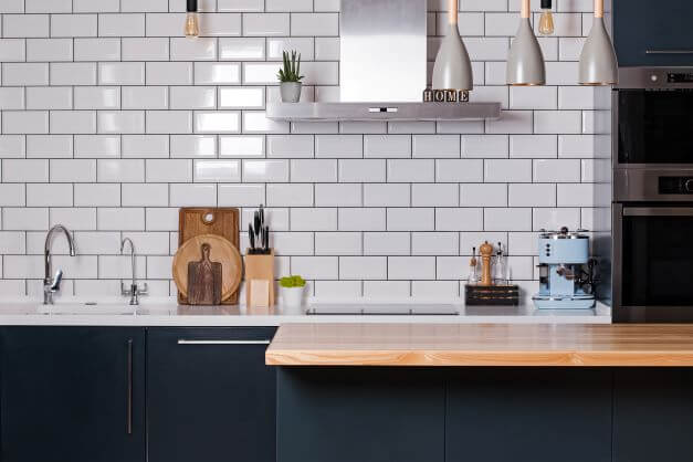 modern style kitchen with white tiles and dark units