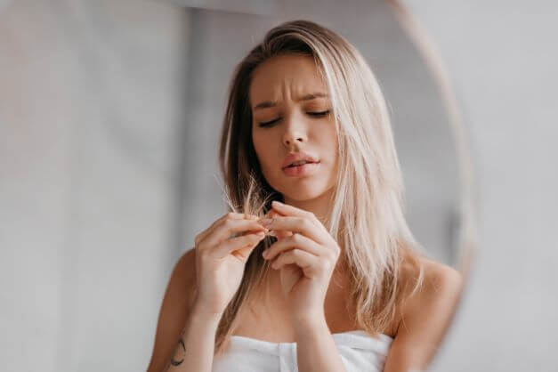 woman looks at split ends