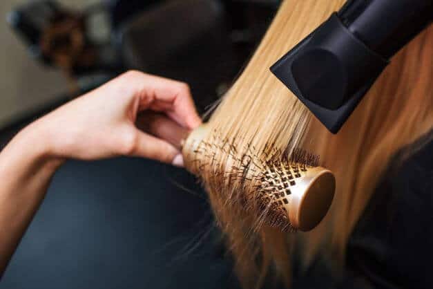 woman styles with professional hair drier