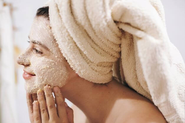 woman using exfoliating facial scrub